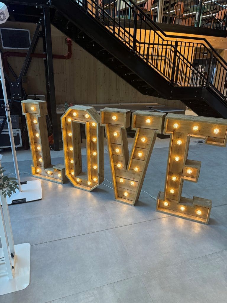 Wooden rustic LOVE sign beside professional wedding DJ setup in Buckinghamshire