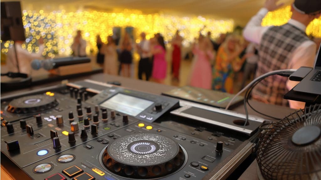 DJ table mixer closeup during the event in Milton Keynes wedding party and dancing people