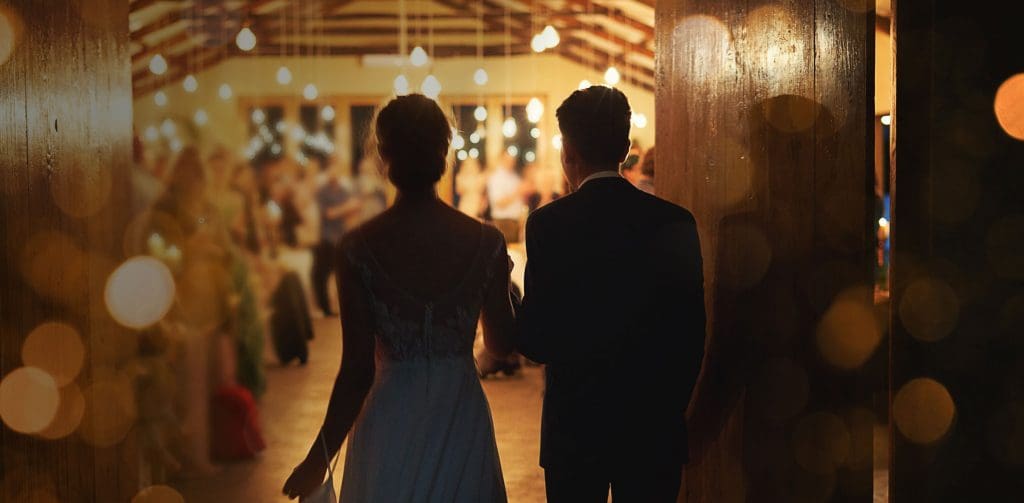 Bride and groom entering reception with romantic lighting – wedding DJ St Albans by AURA sets the perfect mood.