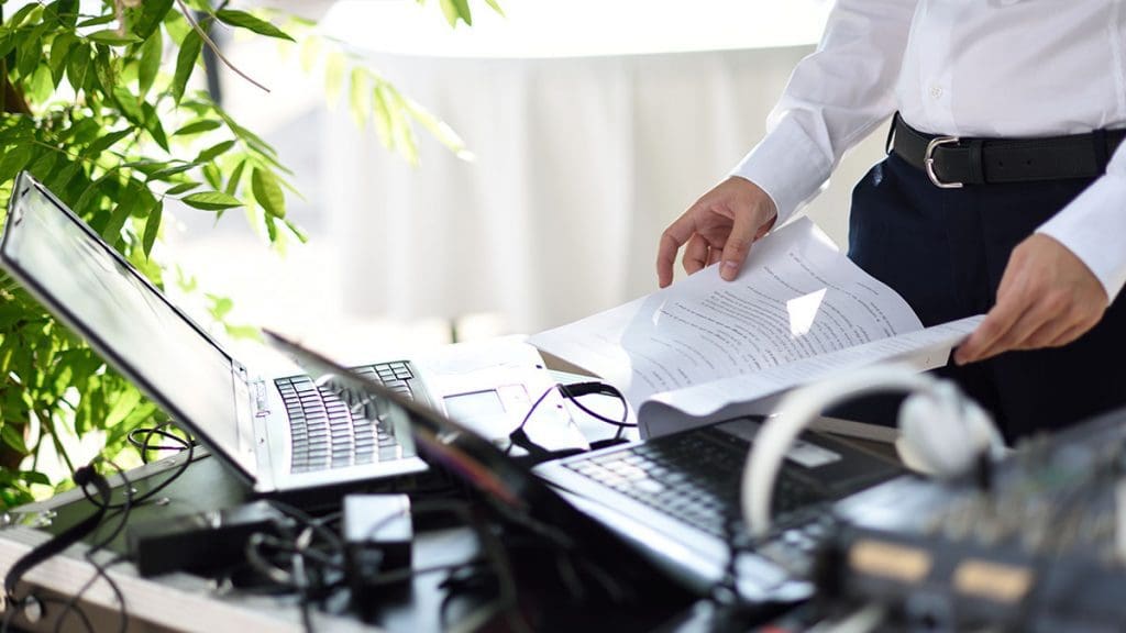Wedding DJ questions - dj reviewing setlist with laptops and sound equipment
