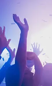 Guests dancing under colourful lights and confetti to Kisstory-style wedding DJ music.