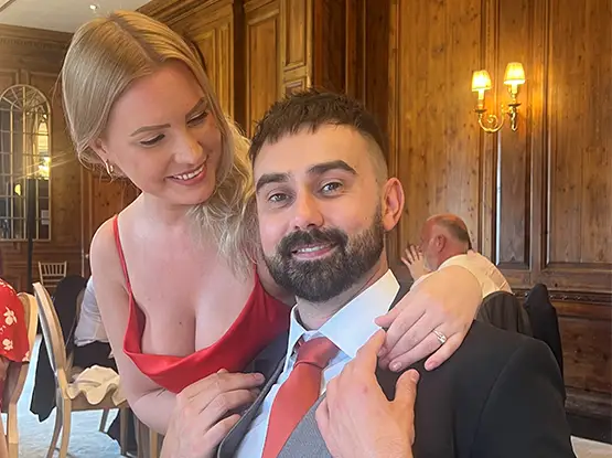 Smiling couple dressed for a wedding, founders of AURA Wedding DJs, bringing personality and professionalism wedding services.