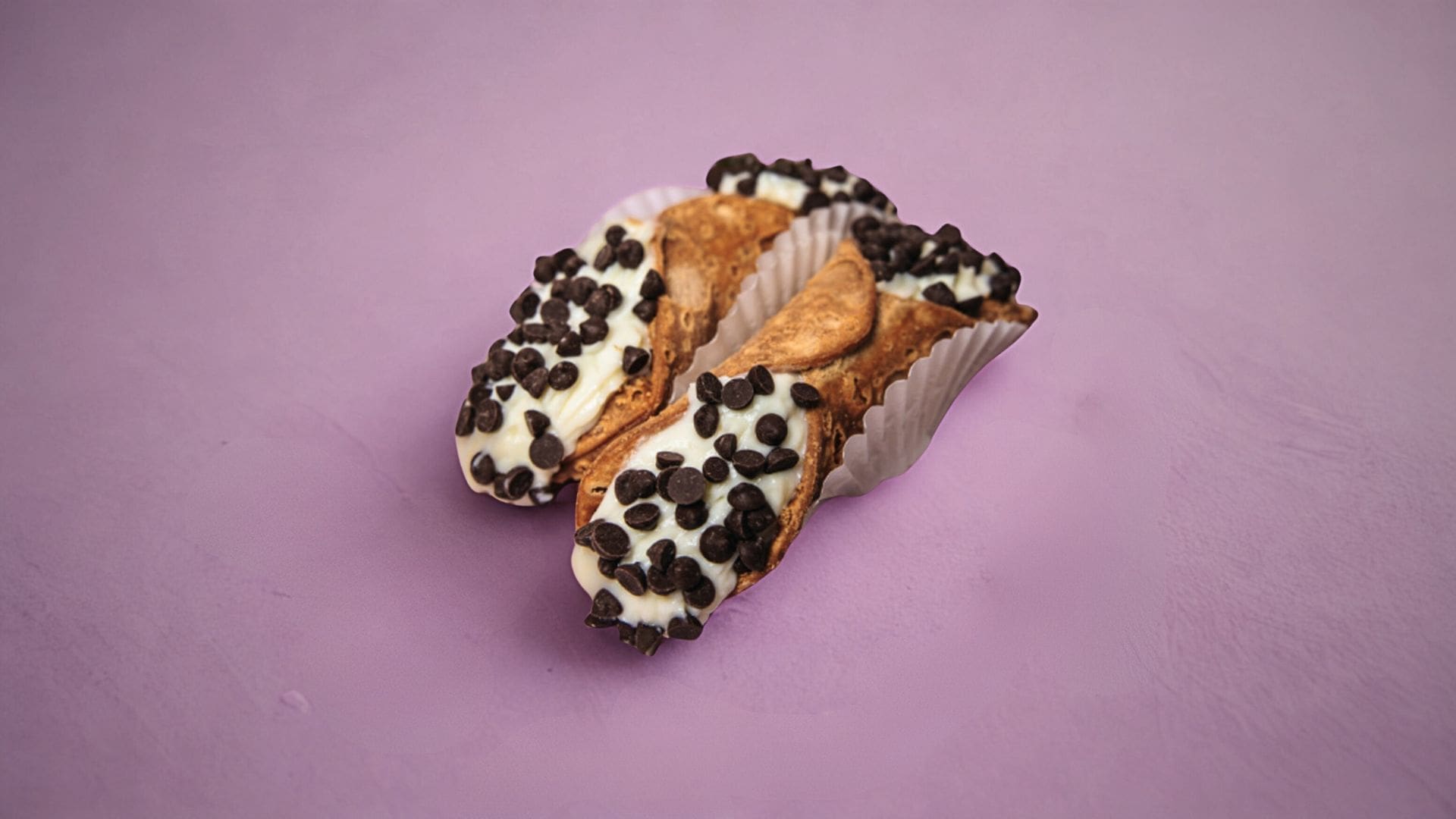 Close-up of freshly filled cannoli with sweet cream and chocolate chips, part of AURA’s Walking Cannoli Bar hire.